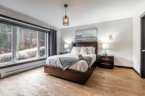 a bedroom with a bed and a large window at Chalet in the Woods, Serenity in Saint Come