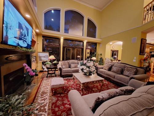 a living room with couches and a flat screen tv at Villa Bellissimo FranTalia in Kelowna