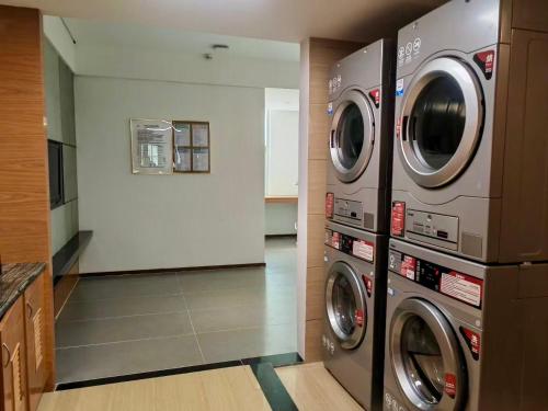 a laundry room with two washer and dryer at Shenzhen Shuidu Holiday Hotel, North Railway Station in Shenzhen