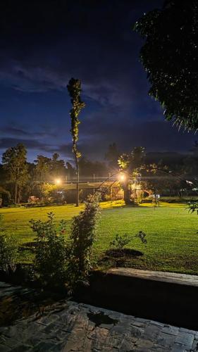 a park at night with a tree in a field at Hideaway By Aahma in Rāmnagar