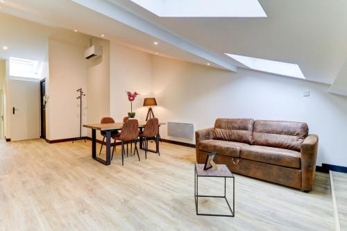 a living room with a couch and a table at La Cambuse - centre ville - 3 étoiles in Bourg-en-Bresse