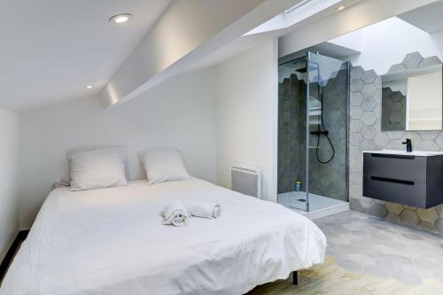a bedroom with a large white bed and a sink at La Cambuse - centre ville - 3 étoiles in Bourg-en-Bresse