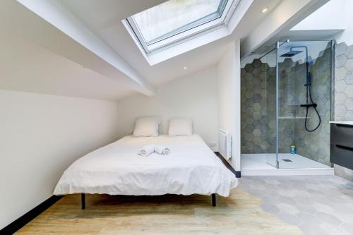 a white bedroom with a bed and a shower at La Cambuse - centre ville - 3 étoiles in Bourg-en-Bresse