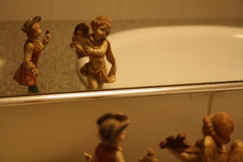 a group of figurines on a shelf next to a bath tub at Ivy Suites in Bhopal