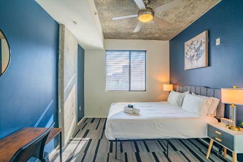 a bedroom with a bed and a blue wall at Adorable 1BD - Central Downtown - Gym, Pool, Parking in Phoenix