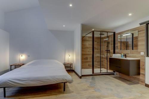 a bedroom with a bed and a shower and a sink at La manufacture - Centre ville - 3 étoiles in Bourg-en-Bresse