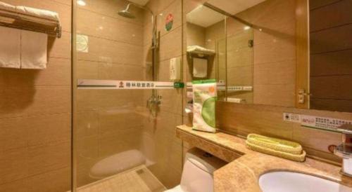 a bathroom with a shower and a sink and a mirror at GreenTree Alliance Shenzhen Shekou Sea World Hotel in Shenzhen