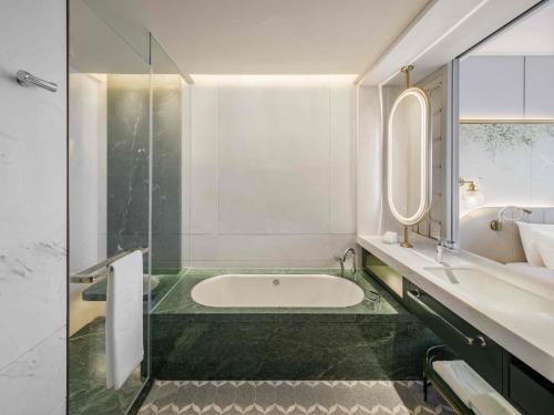 a bathroom with a tub and a sink and a mirror at Shangri-La Nanshan, Shenzhen, Stay for 2 consecutive nights and enjoy breakfast in Shenzhen