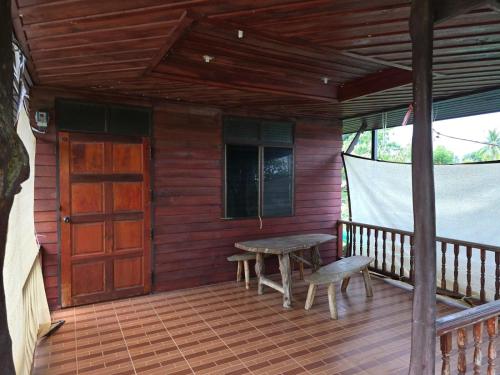トンサラにあるCozy Stay Near Pier, Food & Funの木のポーチ(テーブル付)と木のドア