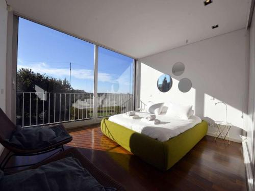 ein Schlafzimmer mit einem Bett und einem großen Fenster in der Unterkunft Lovely Caminha Villa 3 Bedrooms Villa Lilac Private Pool in Caminha