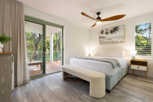 バイロンベイにあるApartment 3 Surfsideのベッドと天井扇風機のある寝室