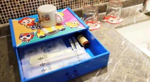 a blue box with pens and a cup on a counter at Wuhan Gleetour Hotel in Wuhan