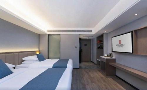 a hotel room with two beds and a flat screen tv at Nanning Prince Hotel in Nanning