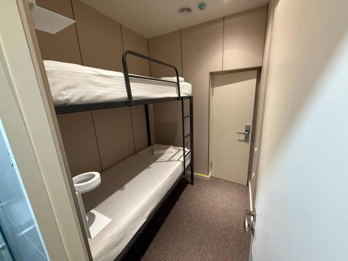 mały pokój z 2 łóżkami piętrowymi i drzwiami w obiekcie City Centre B&B w Taszkiencie