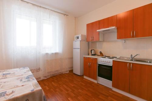 - une cuisine avec des placards en bois et un réfrigérateur blanc dans l'établissement DearHome Avtozavodskaya, à Balashikha