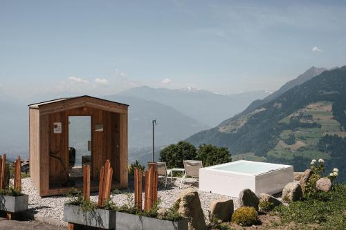 a small building with a pool and a view of a mountain at Ferienwohnungen Wiesbauer in Schenna