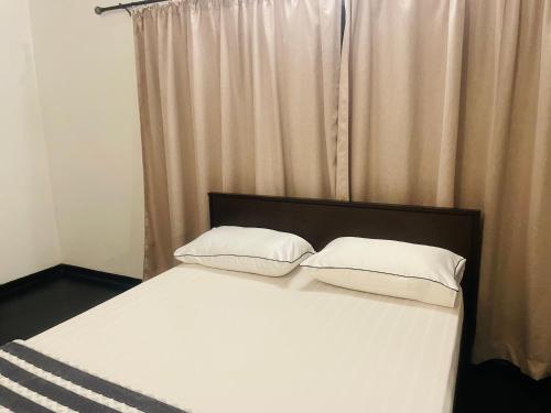 a bedroom with a bed with two white pillows at Mila Boutique Airport in Seeduwa