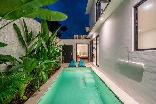 an indoor pool in a house with plants at Nyma Villa in Seminyak