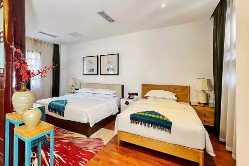 a bedroom with two beds and a vase on a table at No.3 Garden Hotel in Pi-chi Kuan