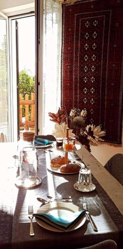 a table with plates and utensils on top of it at Bed & Breakfast Ca' di Camineve in Loano