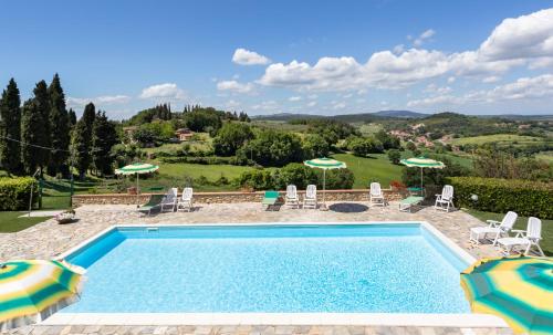 a swimming pool with chairs and umbrellas in a yard at Olivo Cottage - Monti 1824 in Casole dʼElsa