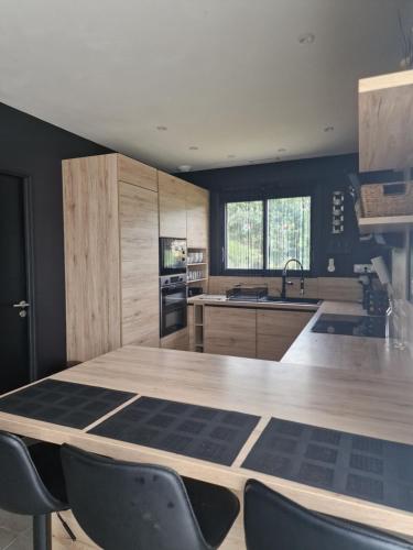 une cuisine avec une grande table et des chaises en bois dans l'établissement Villa en Provence - Sisteron, à Sisteron