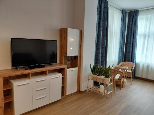 a living room with a flat screen tv on a entertainment center at Haus Troja in Warnemünde