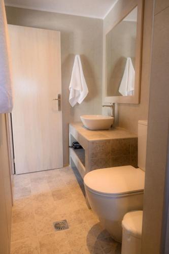 a bathroom with a white toilet and a sink at Exoxiko Summer House in Myrties