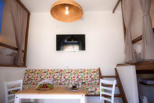 Un comedor con una mesa y un banco con una mesa y sillas. en Exoxiko Summer House, en Myrties
