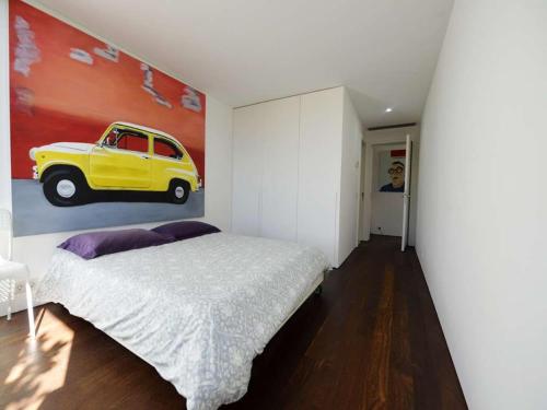 a bedroom with a yellow car painting on the wall at Contemporary Caminha Villa 2 Bedrooms Villa Oceanic Escape Private Pool & Uninterrupted Sea Views North Portugal in Caminha