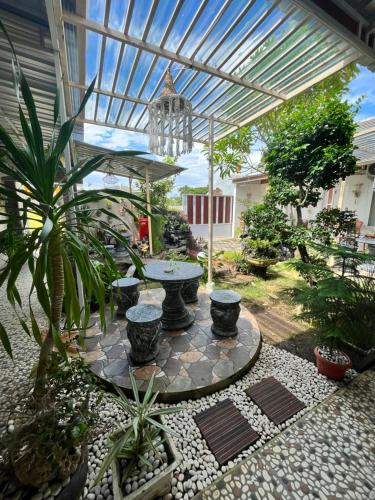 a patio with a table and some plants at Tropical Paradiso Homestay in Banyuwangi