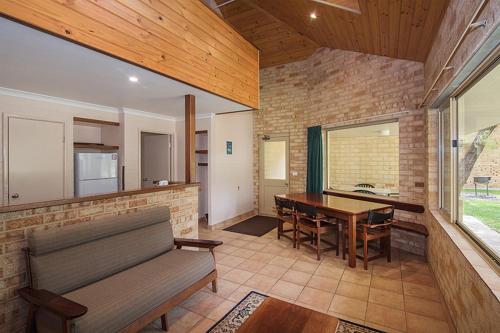 a living room with a bench and a table at Siesta Park Holiday Resort ABSOLUTE BEACHFRONT RESORT in Busselton