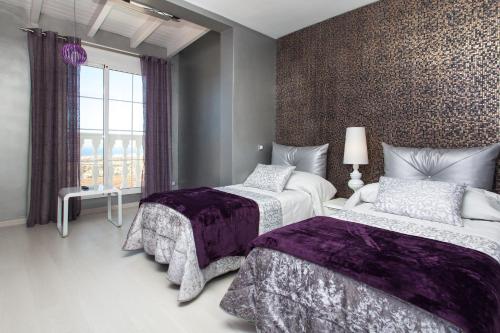 een slaapkamer met twee bedden en een raam bij Suite Golf Caleta Abril in Caleta De Fuste