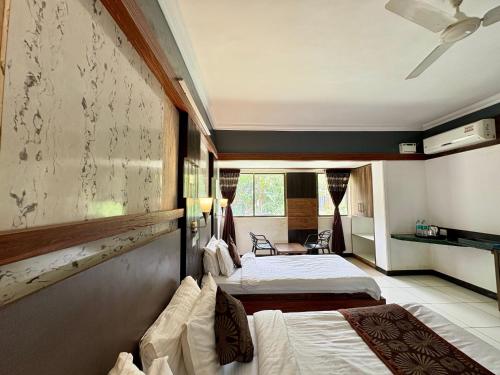 een hotelkamer met twee bedden en een raam bij HoneyBee Resort Lonavala in Lonavala