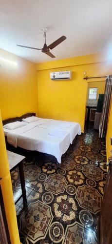 a room with two beds and a yellow wall at Samhen guest house in Majorda