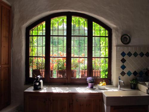 ドルチェードにあるB&B Sul Camminoの大きな窓とシンク付きのキッチンが備わります。