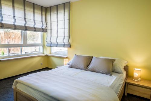 a bedroom with a bed with two pillows and a window at Apartament Skandynawski in Władysławowo