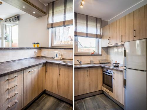 a kitchen with wooden cabinets and a white refrigerator at Apartament Skandynawski in Władysławowo