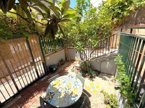 a patio with a table and a balcony with trees at Historical Center with Garden "The Beach and The Cliff" 4 in Agropoli