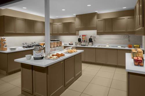 a large kitchen with brown cabinets and food on a counter at Residence Inn Salt Lake City Sandy in Sandy