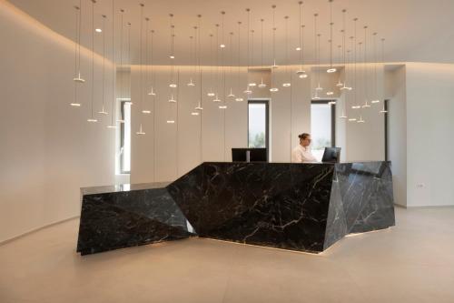 a man is sitting at a desk in a lobby at Mirage Chalkida City Resort in Chalkida