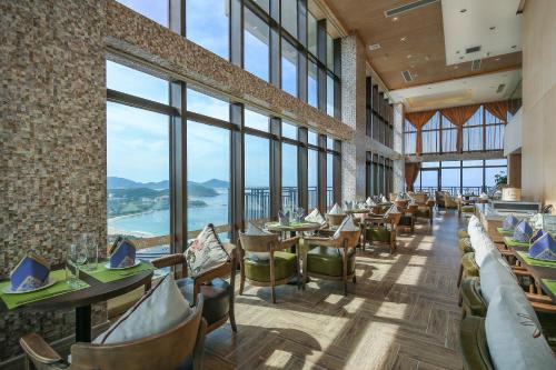 a restaurant with tables and chairs and large windows at Barry Boutique Hotel Sanya in Sanya