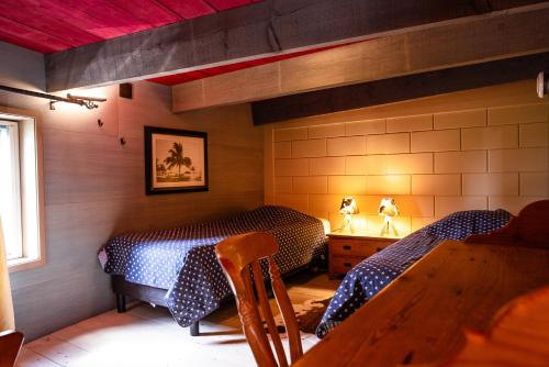 アッカースロートにあるBed&Bbq Longhornranchのベッド2台とテーブルがある部屋