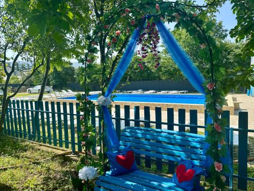 a blue swing with hearts on it in front of a fence at Napoli Nataxtari hotel,pool,bar,kamping in Natakhtari