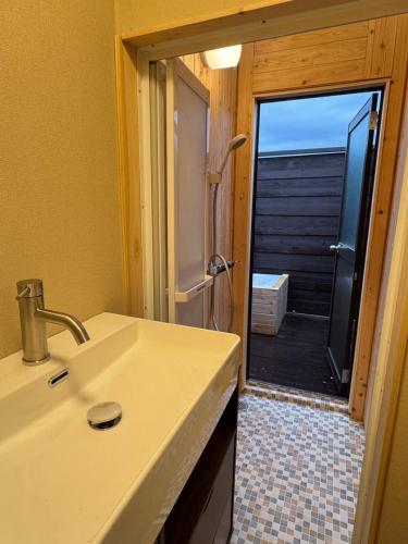 a bathroom with a sink and a view of a deck at 富士見の丘オートキャンプ場 in Fuji