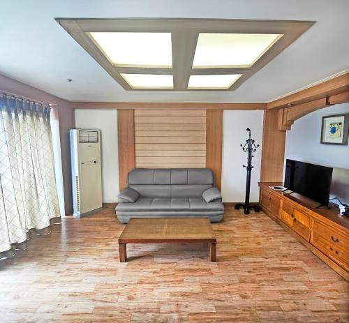 a living room with a couch and a television at Gyeongju Ilsung Condo in Gyeongju
