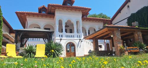 a large white house with a grass field in front of it at Conac Bistreanu in Eforie Sud