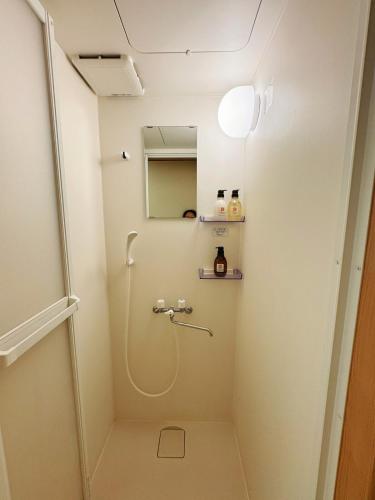 a shower in a bathroom with a showeriterator at Osaka Castle Park Station, 10 minutes walk to Kyobashi Station, direct access to Shinsaibashi, Umeda, Kansai Airport, Kyoto, Nara, USJ, can accommodate up to 10 people in Wada