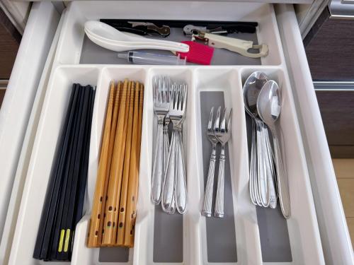 a white tray with utensils in a drawer at Osaka Castle Park Station, 10 minutes walk to Kyobashi Station, direct access to Shinsaibashi, Umeda, Kansai Airport, Kyoto, Nara, USJ, can accommodate up to 10 people in Wada