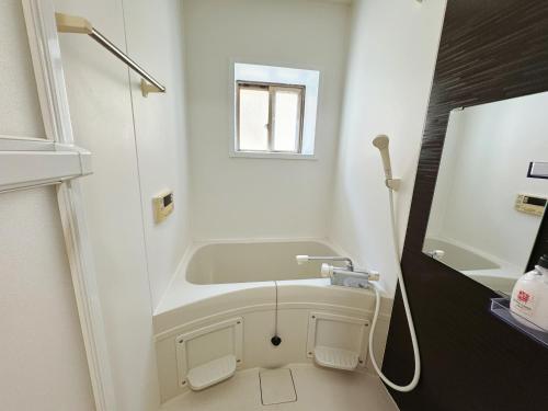 a bathroom with a toilet and a bath tub at Osaka Castle Park Station, 10 minutes walk to Kyobashi Station, direct access to Shinsaibashi, Umeda, Kansai Airport, Kyoto, Nara, USJ, can accommodate up to 10 people in Wada